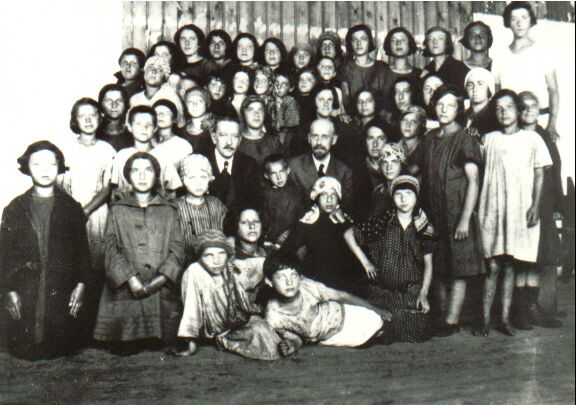 Janusz Korczka wraz z dziećmi pozuje do zdjęcia grupowego.