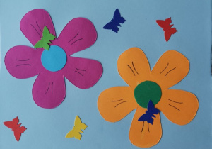 Na niebieskiej kartce fioletowy i pomarańczowy kwiat oraz kolorowe motylki.