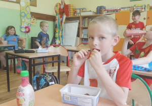 Na zdjęciu uczeń klasy 1a zajada świeże truskawki na drugie śniadanie.