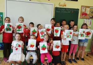 Uczniowie klasy 1a prezentują swoje śliczne, czerwone, truskawkowe prace plastyczne.