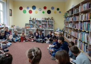 Zdjęcie dzieci siedzących w kole i rozmawiających o wybranych przez siebie książkach.