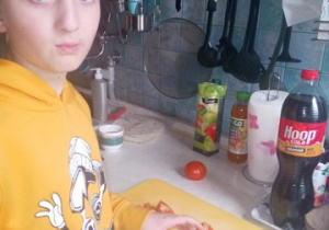 Zdjęcie ucznia, który kroi pomidor.